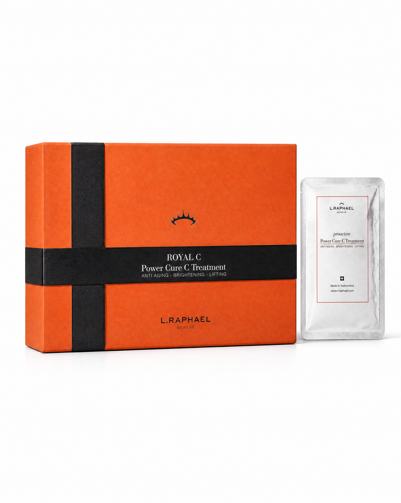 L. Raphael Royal C Power Care C Treatment set, featuring an orange and black gift box next to a single clear sachet with a white label, on a white background.